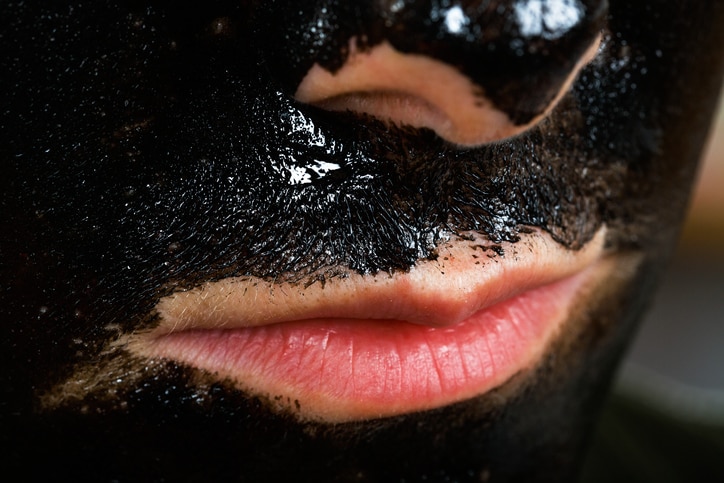 Close up photo of young woman with facial black mask