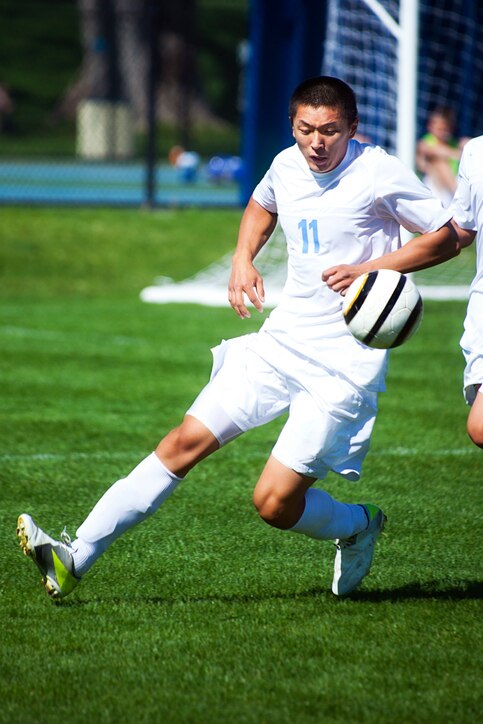 Soccer player concentrates on airborn ball.