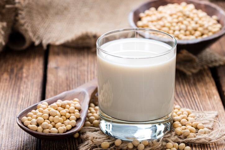 Glass with Soy Milk and Seeds on wooden background