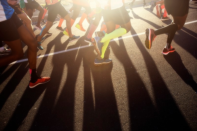 Legs of road runners with shadow on road