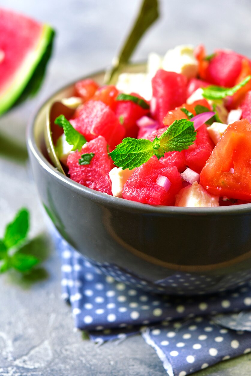 Watermelon salad with feta and mint in a grey bowl.