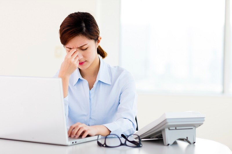 Young businesswoman with tired eyes and headache