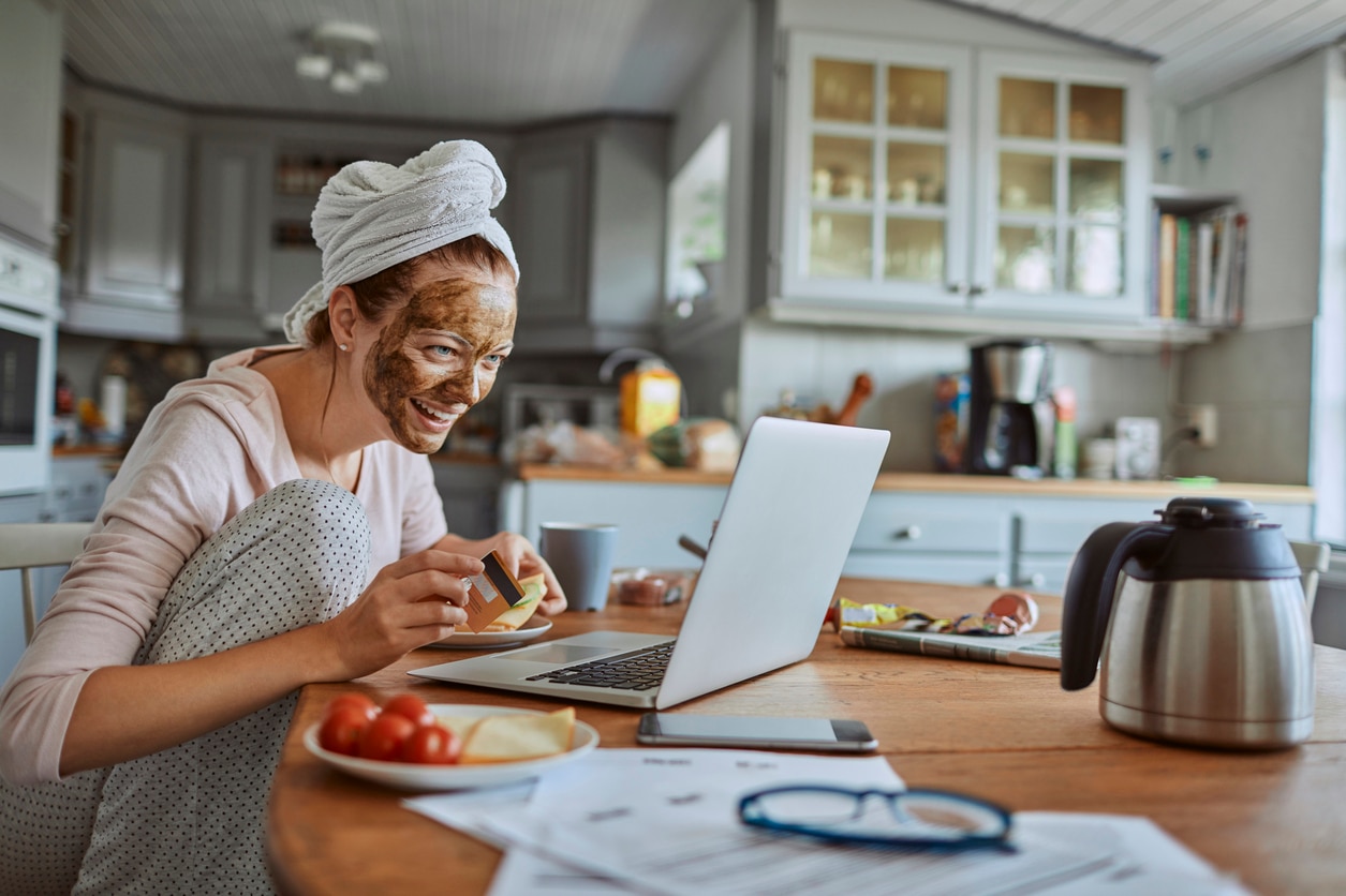 Close up of a young lady having breakfast and using a laptop