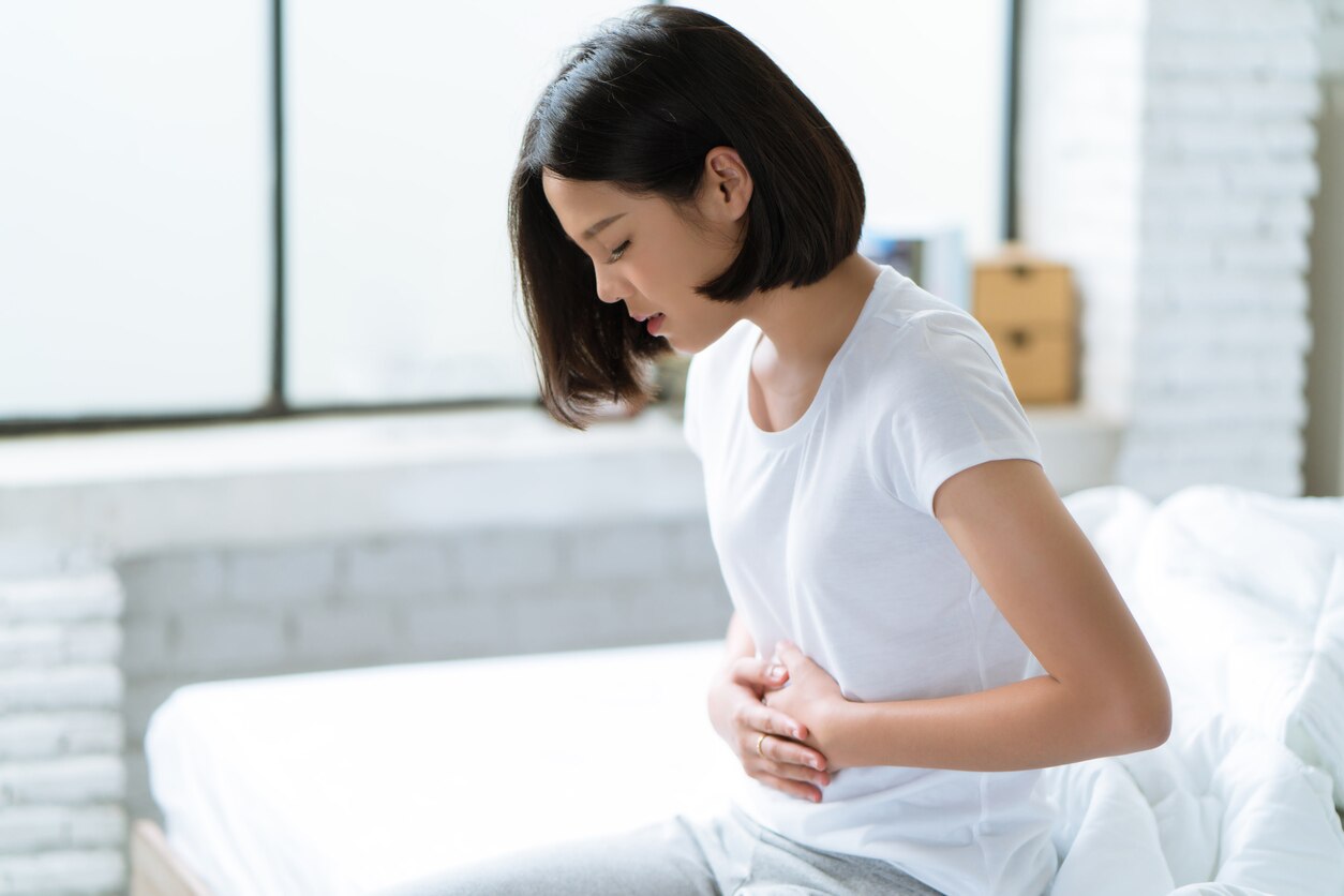 Asian women her stomach aches hard She wakes up in the middle of the night while she sleeps.